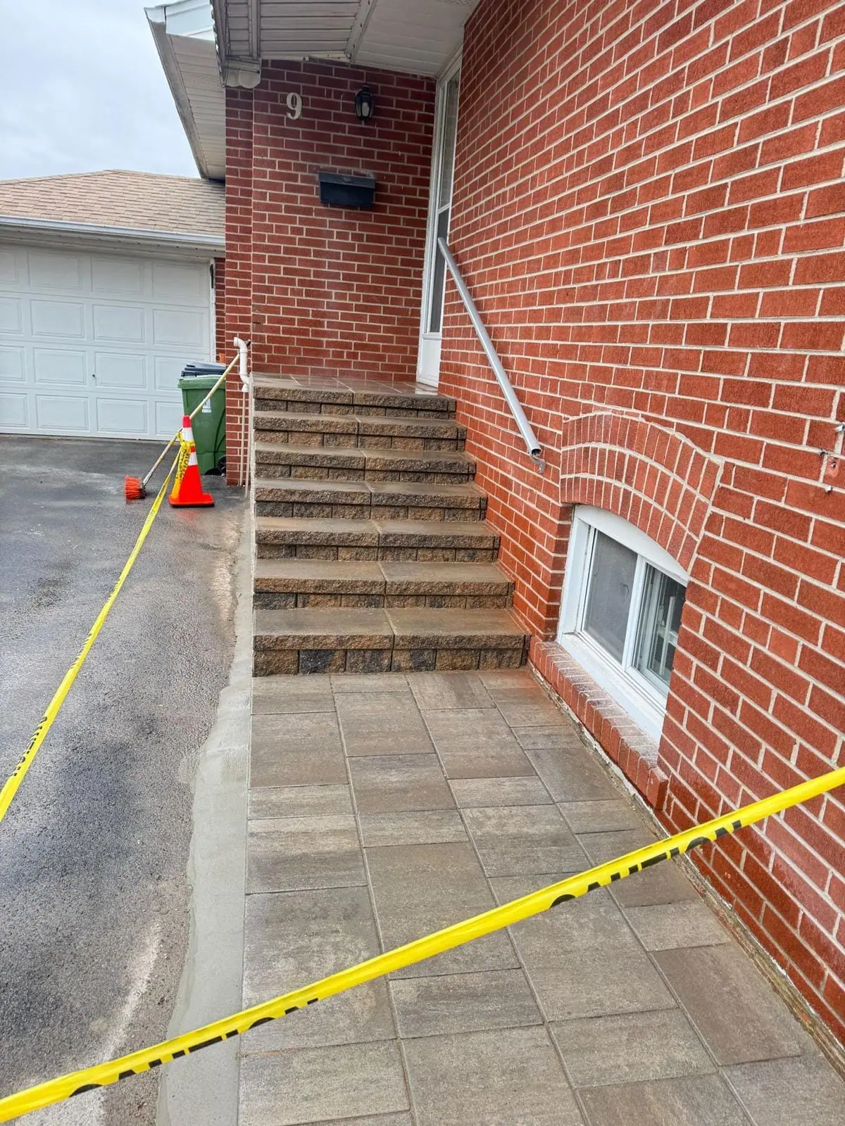 Finished masonry stairs rising to the side door of a red brick house