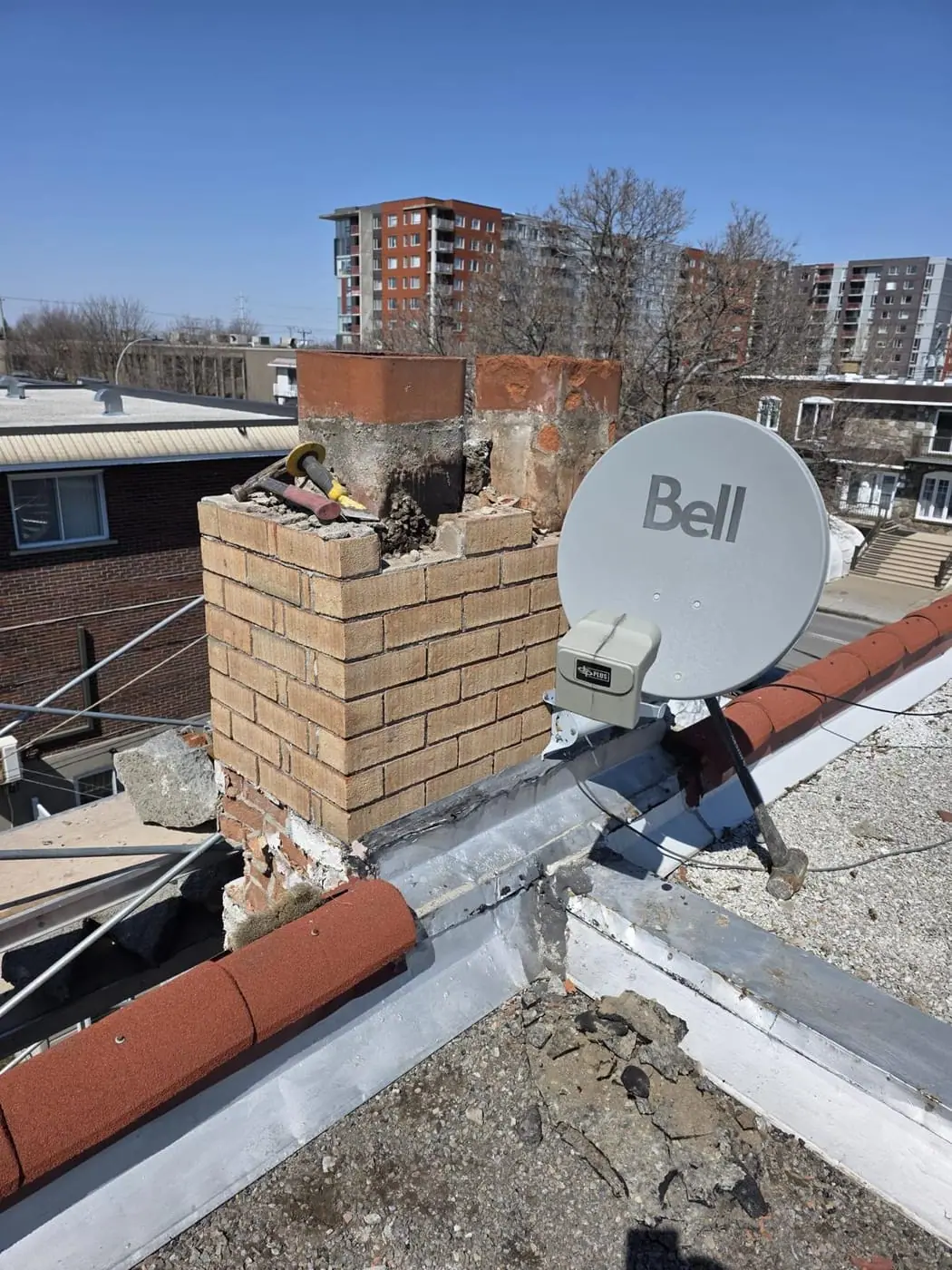 Deteriorated brick chimney top on a flat roof during repair