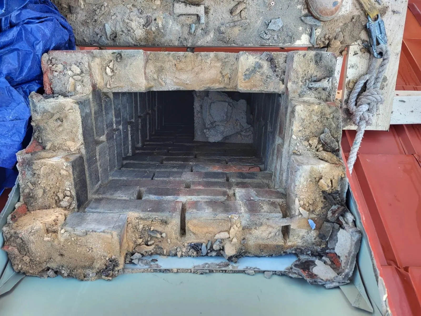 Top-down view of an open chimney flue surrounded by old brick and mortar