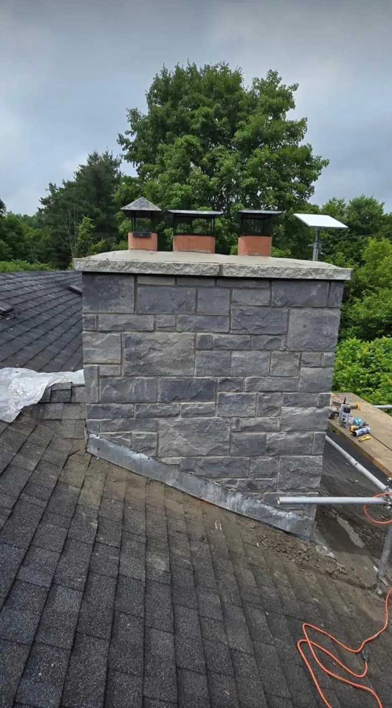 Stone-clad chimney stack on a shingled roof