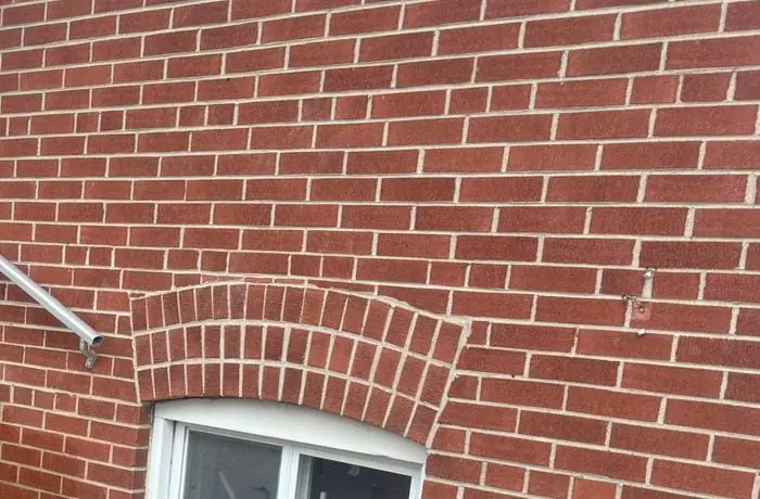 Close detail of red brickwork with an arched soldier course above a window