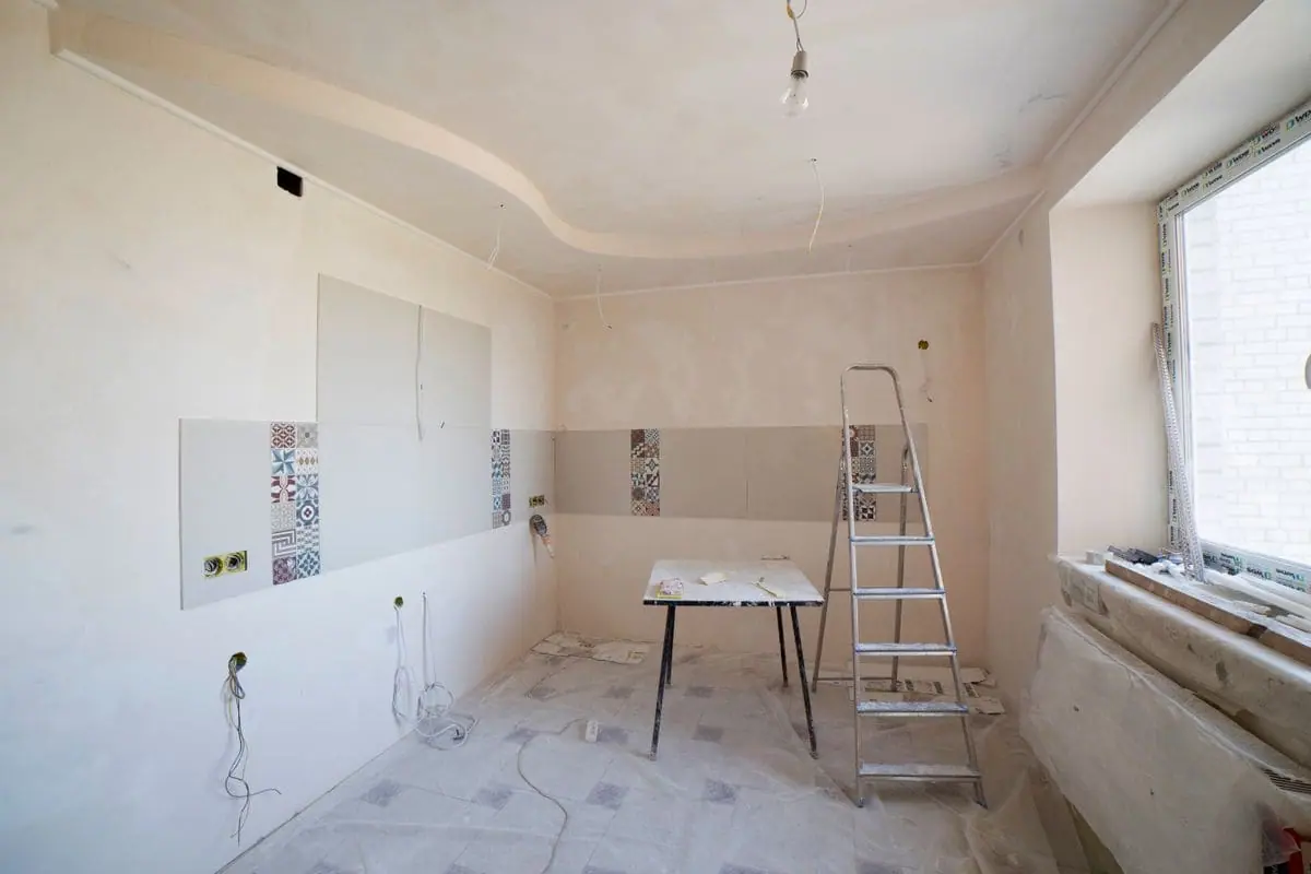 Kitchen mid-renovation with fresh drywall and a stepladder